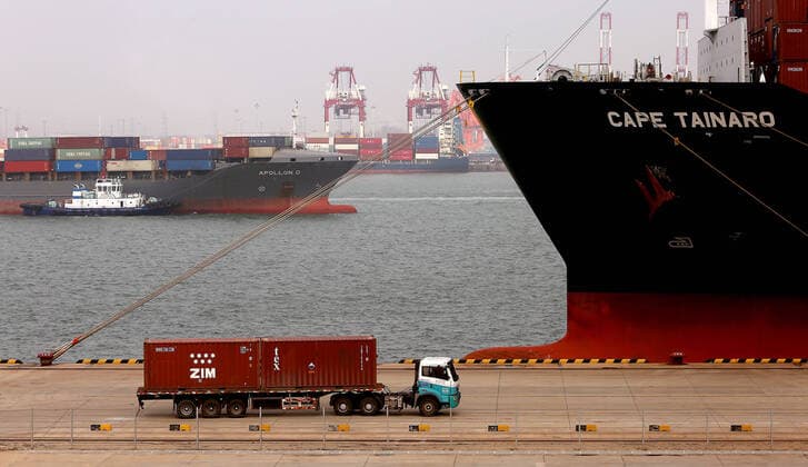Trucks deliver offloaded containers to designated areas at the Qingdao New Qianwan Automatic Container Terminal in Qingdao, Shandong Province, on Monday, October 14, 2019. China currently operates seven of the world s busiest container ports, with Qingdao port ranking eighth in the world.  SDG2019101433 STEPHENxSHAVER