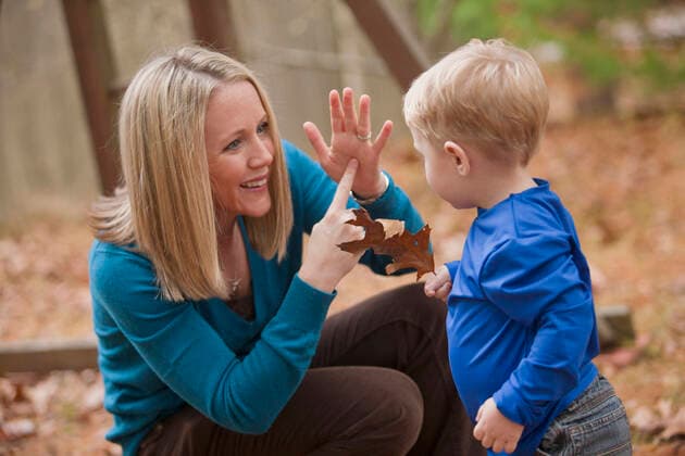 Woman signing the word Leaf in American Sign Language while communicating with her son  Copyright: MarkxHunt 12569304, model released, property released