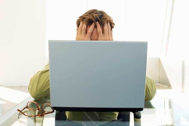 Stressed businessman using laptop in office,model released, Symbolfoto,property released 03B62794