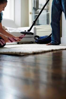 Woman pulling tie from vacuum cleaner in bedroom,model released, Symbolfoto,property released 03B67432