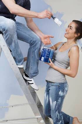 Man on ladder trying to paint woman,model released, Symbolfoto,property released 03B89737