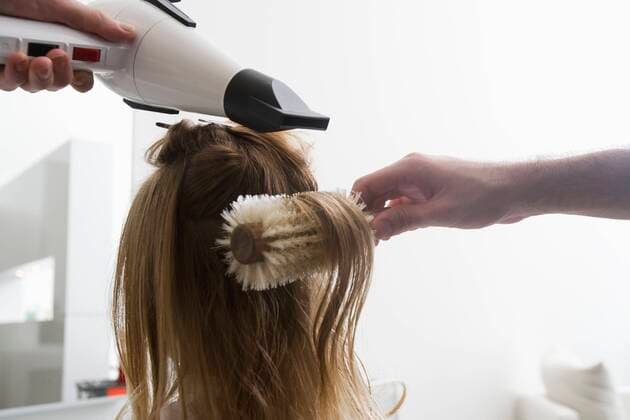 A young woman having her hair dried in the hairdressers,model released, Symbolfoto,property released 03B90706