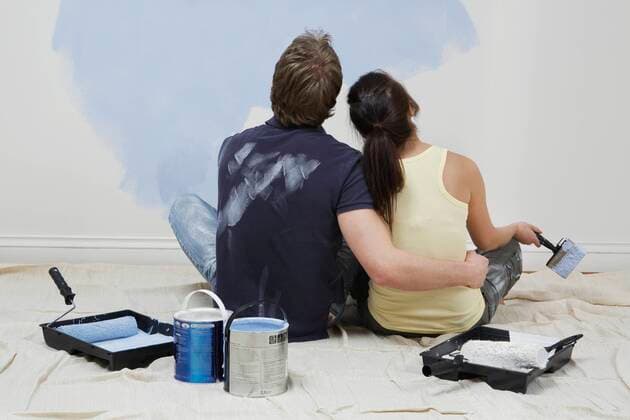 Couple looking up at half-painted wall,model released, Symbolfoto,property released 03B97365