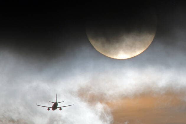 Domestic flights and climate change INTERPOLATION Between cloud gaps in the atmosphere and the sun there is an aircraft after a short domestic flight shortly before Düsseldorf International Airport.