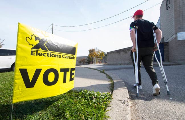(191021) -- TORONTO, Oct. 21, 2019 -- A man walks with crutches to a polling station in Toronto, Canada, Oct. 21, 2019. Canadians on Monday began voting in a general election after a 40-day campaign season. (Photo by Xinhua) CANADA-TORONTO-NATIONAL ELECTION ZouxZheng 