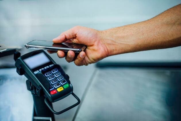 Customer paying contactless with his smartphone model released Symbolfoto  CJMF00113