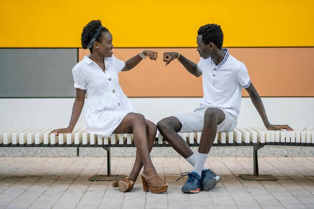 Smiling young woman giving teenage boy a fist bump model released Symbolfoto property released  DLTSF00184