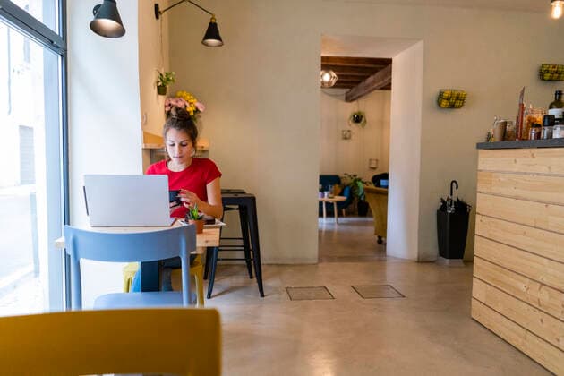 Young woman with cell phone and laptop in a cafe model released Symbolfoto property released  GIOF07128