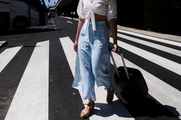 Close-up of young woman with baggage crossing a street at the airport model released Symbolfoto  IGGF01342