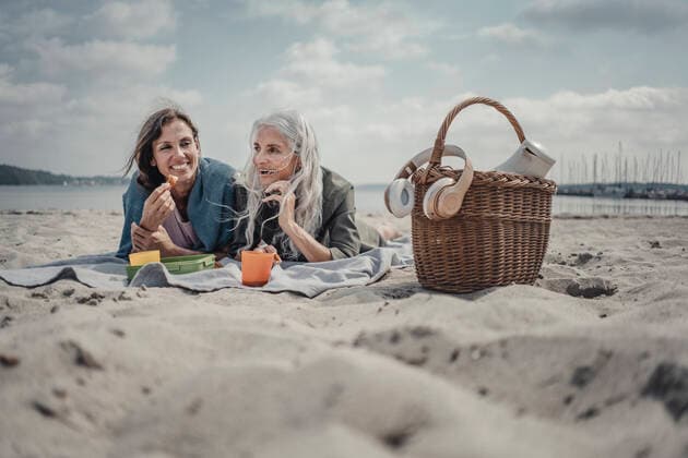 IMAGO Creative: Jahreszeit Frühling, Picknick Mother and daughter having a picnic on the beach model released Symbolfoto  JOSF03760