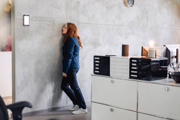 Tired businesswoman leaning against a wall in office model released Symbolfoto property released  KNSF06642