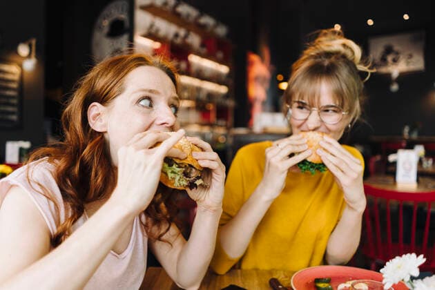Food, Fast Food, Burger Two female friends eating burger in a restaurant model released Symbolfoto property released  KNSF06664