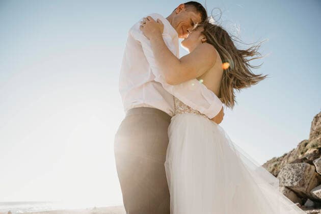 Affectionate bride and groom on the beach at sunset model released Symbolfoto  LHPF00807