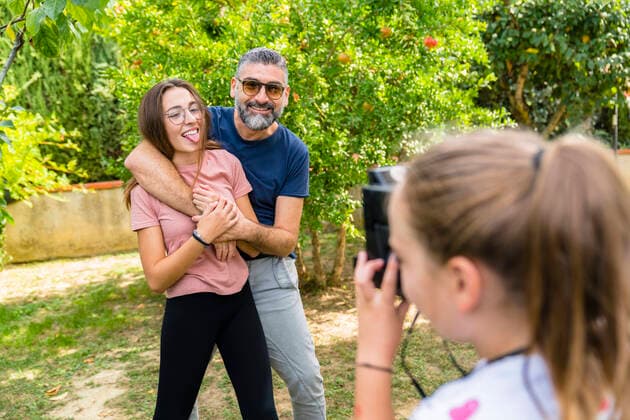 Girl taking a picture of happy father with daughter in garden model released Symbolfoto property released  MGIF00723