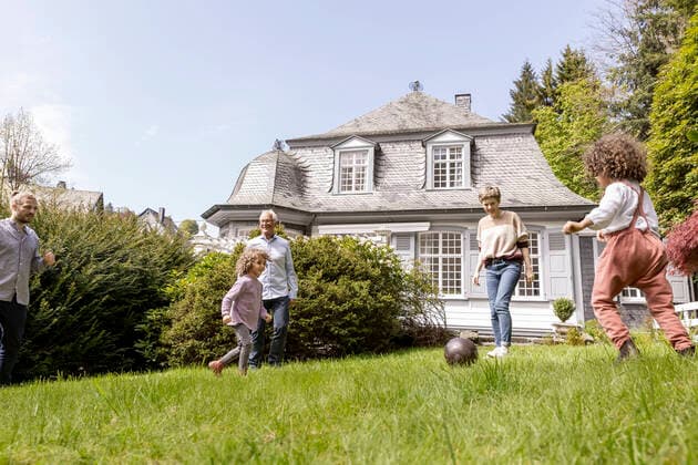 Happy extended family playing football in garden model released Symbolfoto property released  MJFKF00135