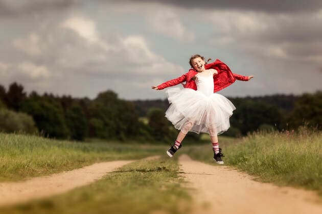 Weltkindertag am 20. September Portrait of happy girl wearing red leather jacket and tutu jumping in the air on dirt track model released Symbolfoto  STBF00413