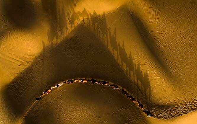 Bilder des Jahres 2019, News 10 Oktober (191028) -- BEIJING, Oct. 28, 2019 -- Aerial photo taken on Oct. 26, 2019 shows tourists riding camels to enjoy the desert scenery at Lop Nur People Village in Yuli County, northwest China s Xinjiang Uygur Autonomous Region. In the first three quarters of this year, Xinjiang received over 183.85 million tourists from home and abroad with a year-on-year increase of 40.9 percent, and saw a total tourism revenue of more than 304.6 billion yuan (about 43.1 billion U.S. dollars) with a year-on-year growth of 40.78 percent. ) XINHUA PHOTOS OF THE DAY ZhaoxGe 