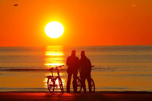 Couple with bikes on the beach watching the sunset, North Sea, St Peter Ording, North Sea coast, Schleswig Holstein Wadden Sea National Park, Schleswig Holstein, Germany, Europe Copyright: imageBROKER/JustusxdexCuveland ibxuve05068096.jpg