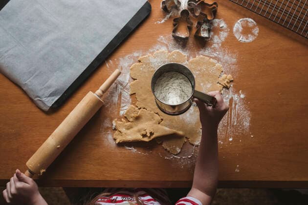 Young girl sifting flour on gingerbread dough New Zealand, Taranaki, Hawera CR_LVBS191016-207946-01