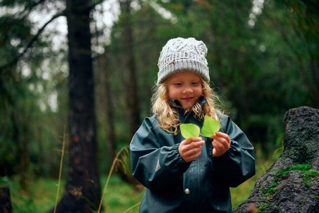 IMAGO Creative: Klimawandel - Umwelterziehung Charming girl in warm hat holding green leaves in forest Ellidaardalur, Reykjavik, Iceland CR_OSBJ191028A-214844-01