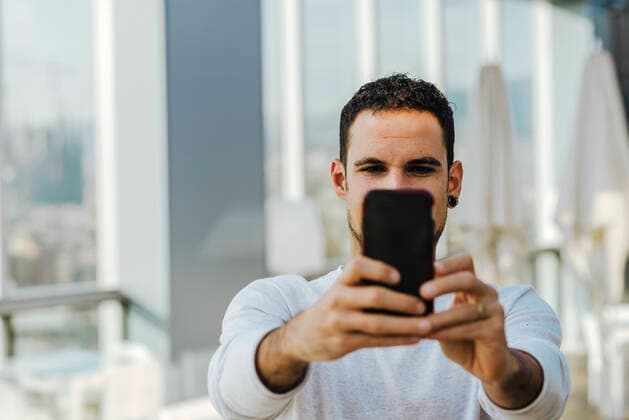 Young man taking a selfie with smartphone Spain, Catalonia, Barcelona CR_RAFE190930C-124057-01
