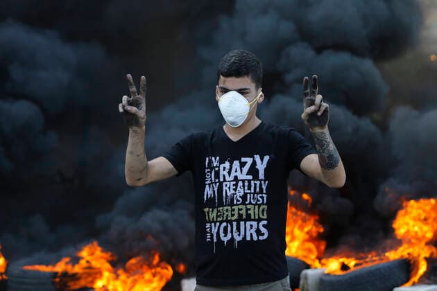Bilder des Jahres 2019, News 11 November News Themen der Woche KW46 News Bilder des Tages (191113) -- BEIRUT, Nov. 13, 2019 (Xinhua) -- A protest gestures in front of burning tyres in Khaldeh, south of Lebanon, on Nov. 13, 2019. Thousands of Lebanese demonstrators blocked streets all over Lebanon on Wednesday to express their outrage over President Michel Aoun s remarks in a televised interview a day earlier and the death of a protester in Khaldeh, south of Lebanon, the National News Agency reported. (Photo by Bilal Jawich Xinhua) LEBANON-NATIONWIDE PROTESTS 