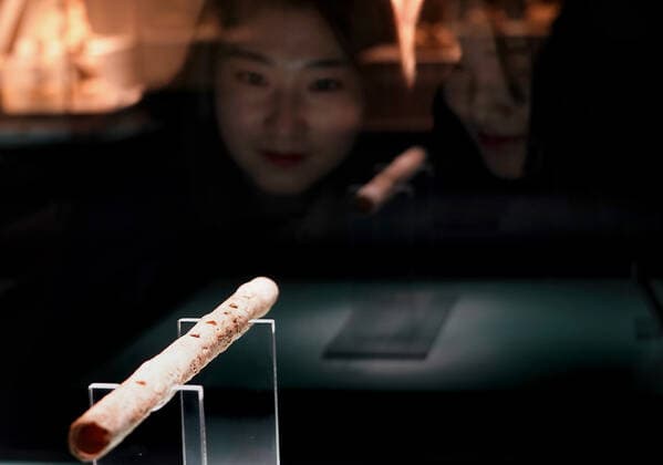 (191120) -- ZHENGZHOU, Nov. 20, 2019 -- A visitor looks at a jade flute during an exhibition on music and dancing along the ancient Silk Road in Zhengzhou, central China s Henan Province, on Nov. 19, 2019. More than 280 artifacts dating back to ancient China s Han, Tang, Song and Yuan dynasties are on display during the exhibition. ) CHINA-ZHENGZHOU-SILK ROAD-EXHIBITION (CN) LixAn 