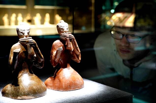 (191120) -- ZHENGZHOU, Nov. 20, 2019 -- A visitor looks at a pair of music-playing figurines during an exhibition on music and dancing along the ancient Silk Road in Zhengzhou, central China s Henan Province, on Nov. 19, 2019. More than 280 artifacts dating back to ancient China s Han, Tang, Song and Yuan dynasties are on display during the exhibition. ) CHINA-ZHENGZHOU-SILK ROAD-EXHIBITION (CN) LixAn 