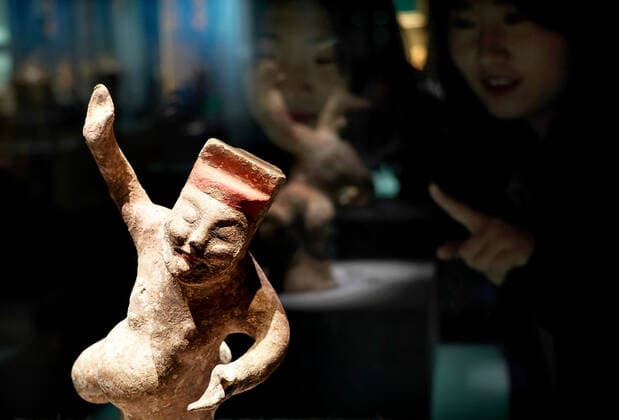 (191120) -- ZHENGZHOU, Nov. 20, 2019 -- Visitors look at a dancing figurine during an exhibition on music and dancing along the ancient Silk Road in Zhengzhou, central China s Henan Province, on Nov. 19, 2019. More than 280 artifacts dating back to ancient China s Han, Tang, Song and Yuan dynasties are on display during the exhibition. ) CHINA-ZHENGZHOU-SILK ROAD-EXHIBITION (CN) LixAn 