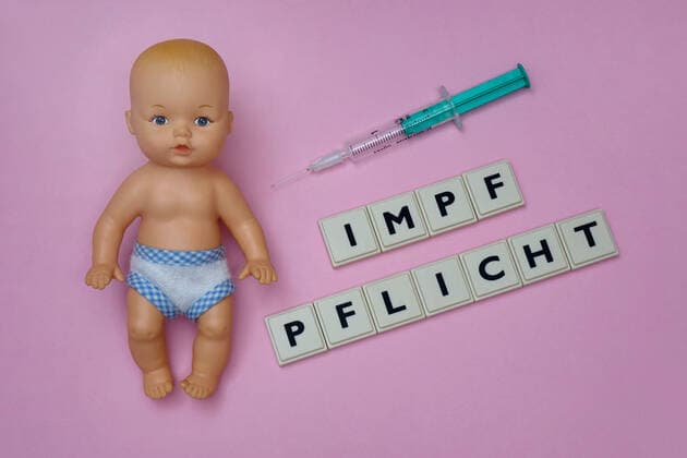 Babypuppe und Impfpflicht Babypuppe und Impfpflicht, 20 11 2019, Borkwalde, Brandenburg, Germany, Next to a baby doll there is a syringe and the inscription Impfpflicht (compulsory vaccination)