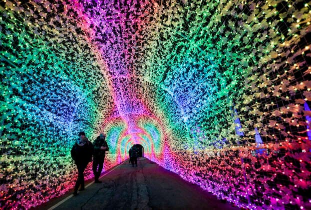(191122) -- VANCOUVER, Nov. 22, 2019 (Xinhua) -- People walk through a light tunnel during the Aurora Winter Festival in Vancouver, Canada. Nov. 21, 2019. Fifteen acres of open space are turned into a winter wonderland during the Aurora Winter Festival with light displays and holiday themed attractions. (Photo by Liang Sen Xinhua) CANADA-VANCOUVER-WINTER-FESTIVAL 