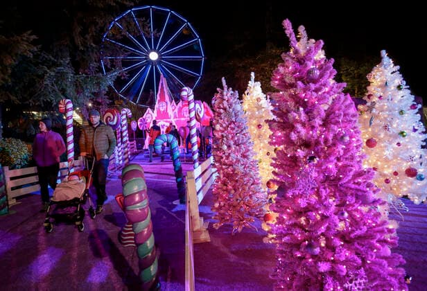 (191122) -- VANCOUVER, Nov. 22, 2019 (Xinhua) -- People walk past decorations during the Aurora Winter Festival in Vancouver, Canada. Nov. 21, 2019. Fifteen acres of open space are turned into a winter wonderland during the Aurora Winter Festival with light displays and holiday themed attractions. (Photo by Liang Sen Xinhua) CANADA-VANCOUVER-WINTER-FESTIVAL 