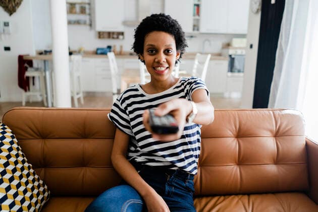 Portrait of smiling young woman watching Tv at home model released Symbolfoto property released  GIOF07795