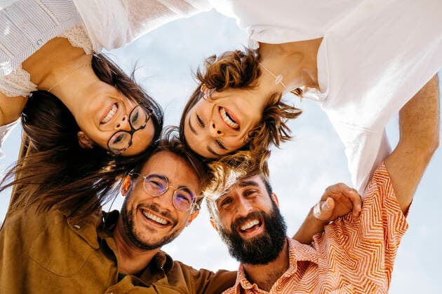 Portrait of happy friends huddling outdoors model released Symbolfoto  JRFF03843