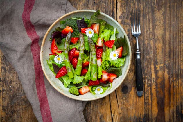 Close-up of salad with green asparagus, strawberries and daisies  LVF08316