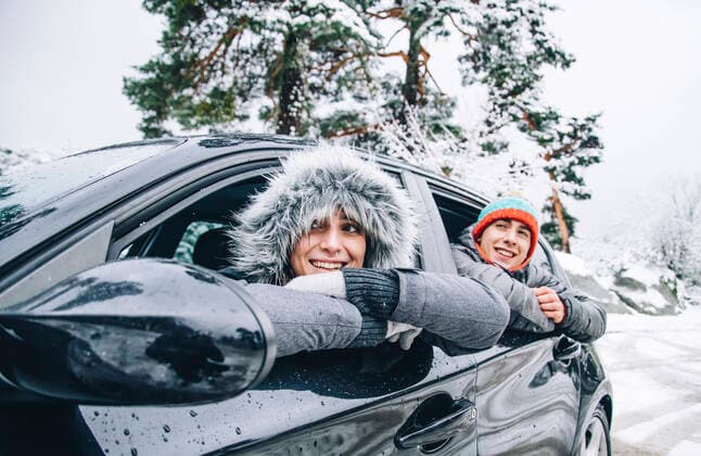 IMAGO Creative: Countdown bis Weihnachten, Nach Hause reisen Portrait of happy young couple sitting in a car in winter forest having fun model released Symbolfoto  OCMF00935