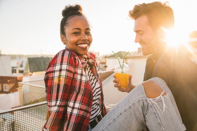 Happy young couple having a drink on rooftop at sunset model released Symbolfoto property released  UUF19467