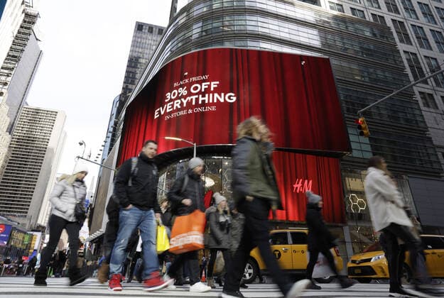 Bilder des Jahres 2019, News 11 November News Themen der Woche KW48 News Bilder des Tages Shoppers holding bags from retail stores walk by discount Black Friday signs in Times Square on Black Friday in New York City on Friday, November 29, 2019. For over a decade, Black Friday has traditionally been the official start to the busy buying binge sandwiched between Thanksgiving and Christmas.  NYP20191129114 JOHNxANGELILLO
