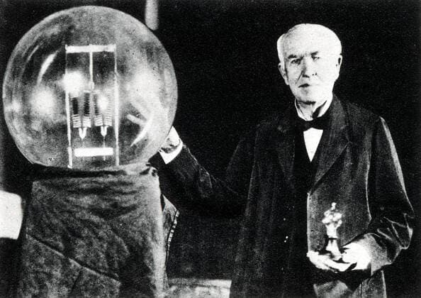 EDISON EDISON et sa premiere lampe a incandescence, photographie prise pour le cinquantenaire de la lampe electrique en 1929, dans sa main gauche il tient sa premiere ampoule dite de 16 bougies et a droite une lampe moderne de 150 000 . Credit Collection Kharbine Tapabor *** EDISON EDISON and his first incandescent lamp, photograph taken for the fiftieth anniversary of the electric lamp in 1929, in his left hand he holds his first bulb called 16 candles and on the right a modern lamp of 150 000 Credit Collection Kharbine Tapabor  KH12091