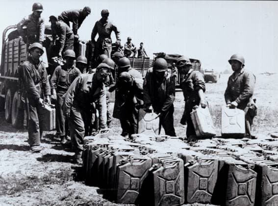 Debarquement de juin 1944 Soldats americains deposant des jericans de fuel sur un terrain d aviation allie situe sur la cote nord, juste avant le debarquement. Juin 1944. Credit : Coll. D-U Kharbine-Tapabor. *** June 1944 landing American soldiers depositing fuel jericans on an allied airfield located on the north coast, just before landing June 1944 Credit Coll D U Kharbine Tapabor  KH39120