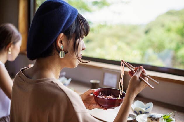 Two Japanese women sitting at a table in a Japanese restaurant, eating. Two Japanese women sitting at a table in a Japanese restaurant, eating.  59822