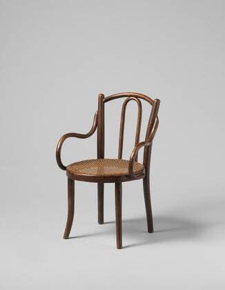 Designklassiker von Michael Thonet Children s chair with curved legs and back posts and a seat frame covered with matting, Children s chair made of curved beech wood resting on four legs. The curved hind legs extend into the pillars of the backrest with a slightly curved upper sill. The backrest has a curved horseshoe shape in the middle. The S-shaped curved armrests are attached from the center of the back posts and continue along the sides of the seat frame. The seat consists of a round frame covered with matting, Gebrüder Thonet, Austria, c. 1850 - c. 1880, wood (plant material), beech (wood), rattan, h 62.5 cm x w 40.0 cm x d 39.0 cm  Copyright Artokoloro LCK_190715_012058