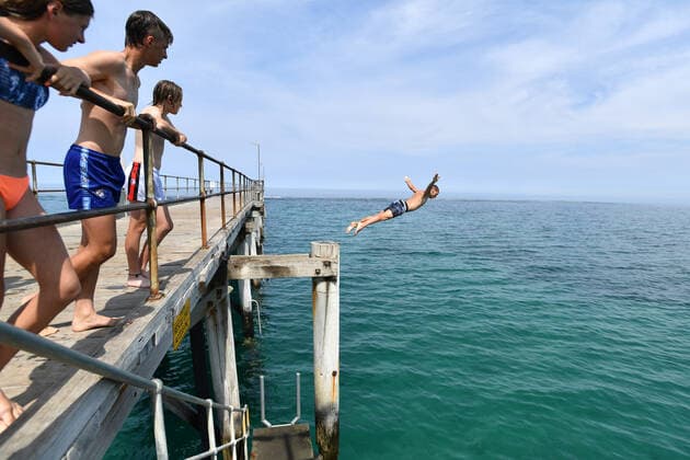 ADELAIDE HOT WEATHER, A swimmer jumps from the Port Noarlunga Jetty in Adelaide, Tuesday, December 17, 2019. A heatwave spreading across Australia is expected to see parts of the nation swelter through temperatures close to 50C. ( NO ARCHIVING, EDITORIAL USE ONLY, NO USE IN BOOKS WITHOUT CONSENT ADELAIDE SA AUSTRALIA  Copyright: xDAVIDxMARIUZx 20191217001438288088