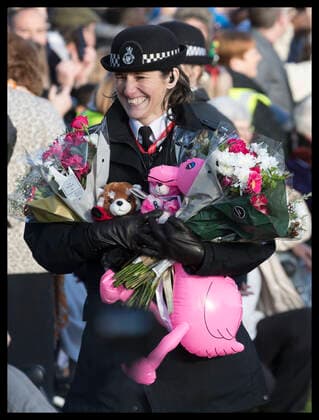 . 25 12 2019. Sandringham, United Kingdom. A policewoman with flowers and gifts given to the Royal family after they left the Christmas Day church service at Sandringham in Norfolk, United Kingdom.  xStephenxLockx xi-Imagesx IIM-20597-0068