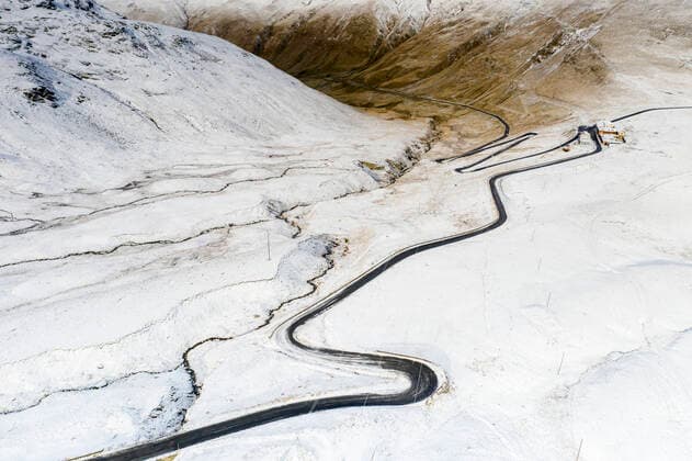 Aerial view by drone of S-shape road towards Stelvio Pass in the snowy landscape, Bormio, Sondrio province, Valtellina, Lombardy, Italy, Europe Copyright: RobertoxMoiola 1179-4090