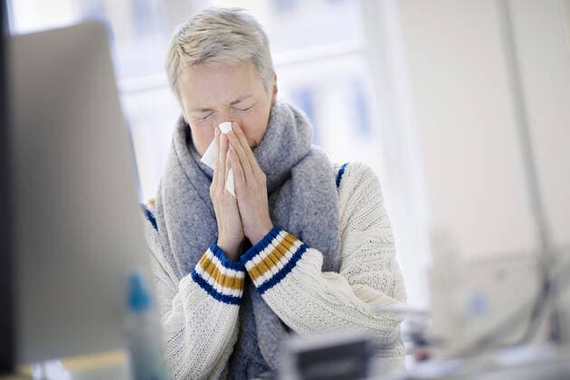 Gestelltes Symbolfoto zum Thema krank am Arbeitsplatz . Eine Frau sitzt sich an ihrem Schreibtisch und putzt sich die Nase. Berlin, 03.01.2020. Berlin Deutschland *** A woman sits at her desk and cleans her nose Berlin, 03 01 2020 Berlin Germany Copyright: xThomasxTrutschel photothek.dex