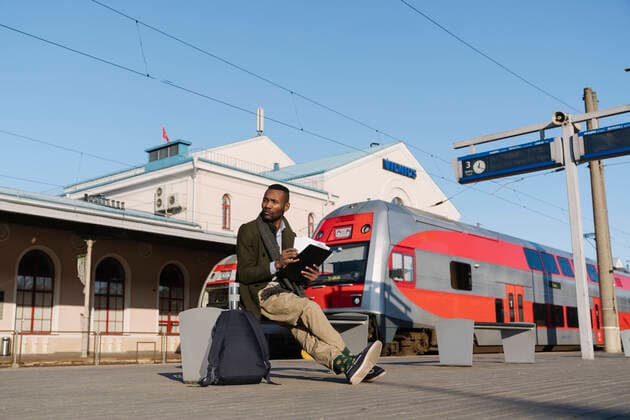 Stylish man with documents waiting for the train model released Symbolfoto  AHSF01621