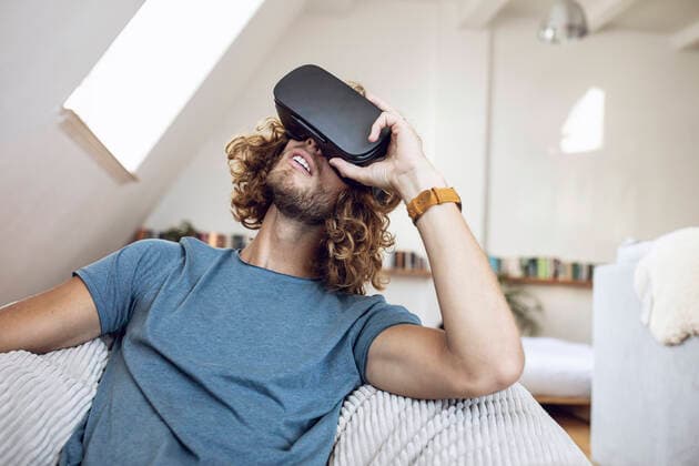 Young man wearing VR glasses at home model released Symbolfoto property released  MCF00405