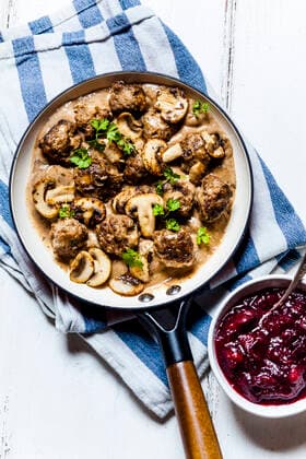 Frying pan with Swedish kottbullar meatballs in mushroom gravy and bowl of mashed cranberries  SBDF04053