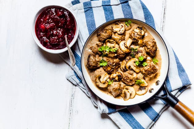 Frying pan with Swedish kottbullar meatballs in mushroom gravy and bowl of mashed cranberries  SBDF04054